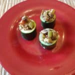 3 lentil and walnut stuffed zucchini cups on red plate