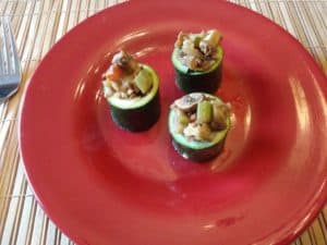 3 lentil and walnut stuffed zucchini cups on red plate
