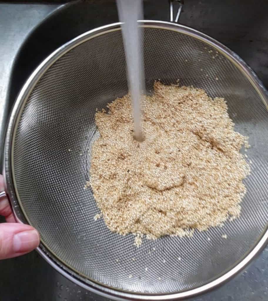 quinoa being rinsed in colander