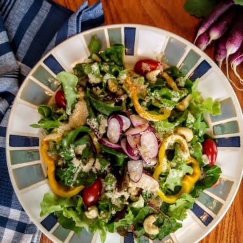 Salad with tahini dressing and bunch of purple radishes