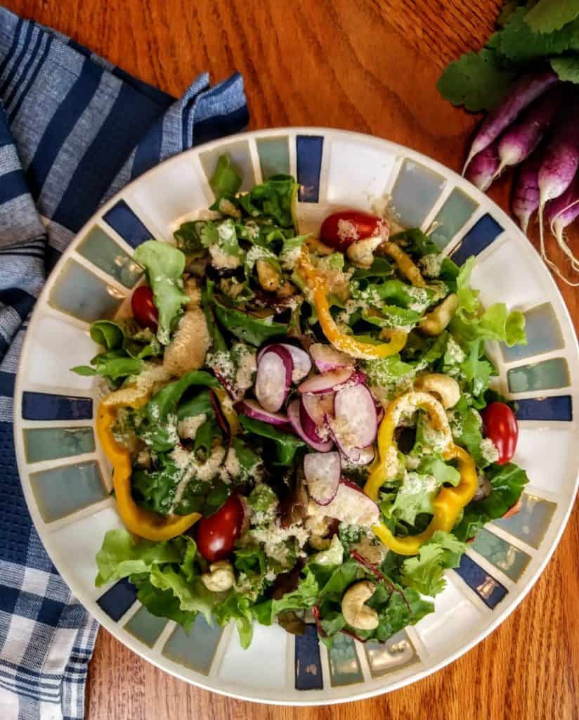 Salad with tahini dressing and bunch of purple radishes