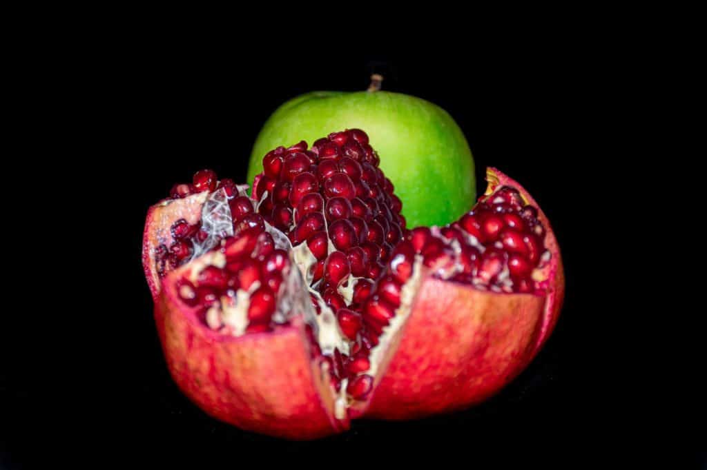 Pomegranate cut open with green apple