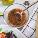 tomato lime salad dressing with spoon with baguette and salad