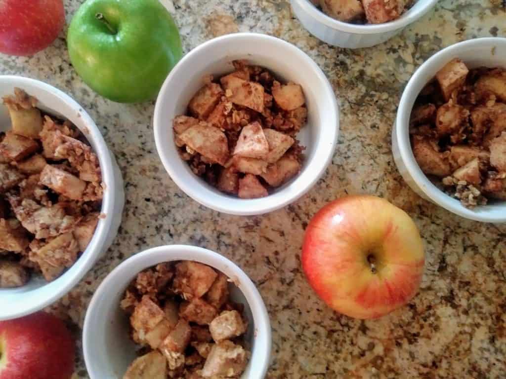 white dishes of apple crisp with green and red apples