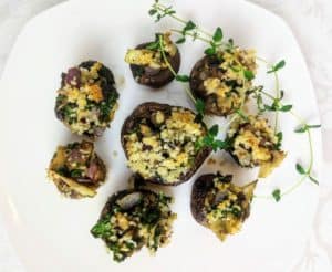 vegan stuffed mushrooms with mushrooms and kale on white plate with fresh thyme
