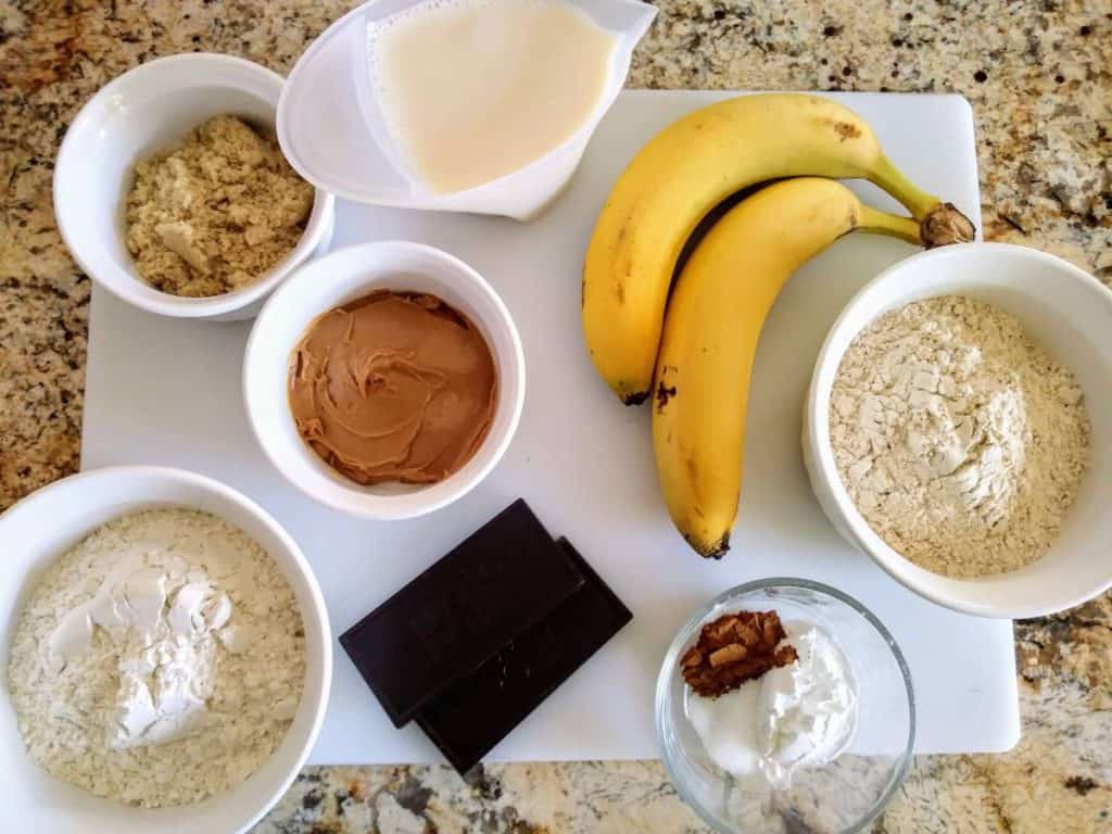 ingredients for vegan peanut butter banana muffins in small bowls