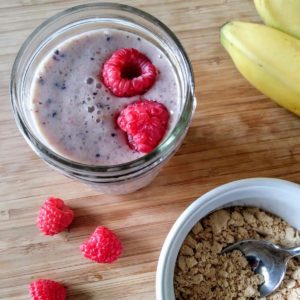 vegan peanut butter smoothie with raspberries, bananas, and peanut butter powder