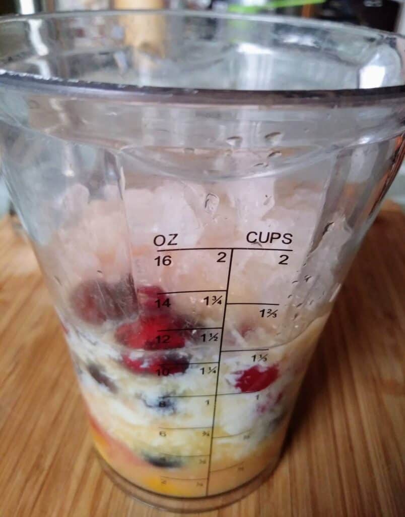 cranberry mango smoothie ingredients in blender cup