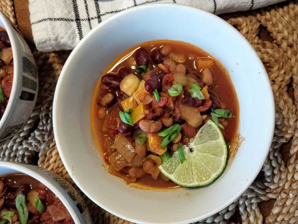 slow cooker vegan chili in bowl with slice of lime.