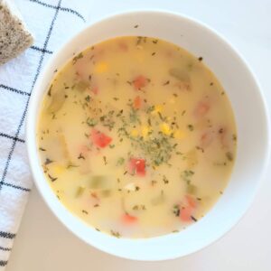 vegetable corn chowder in bowl with bread.