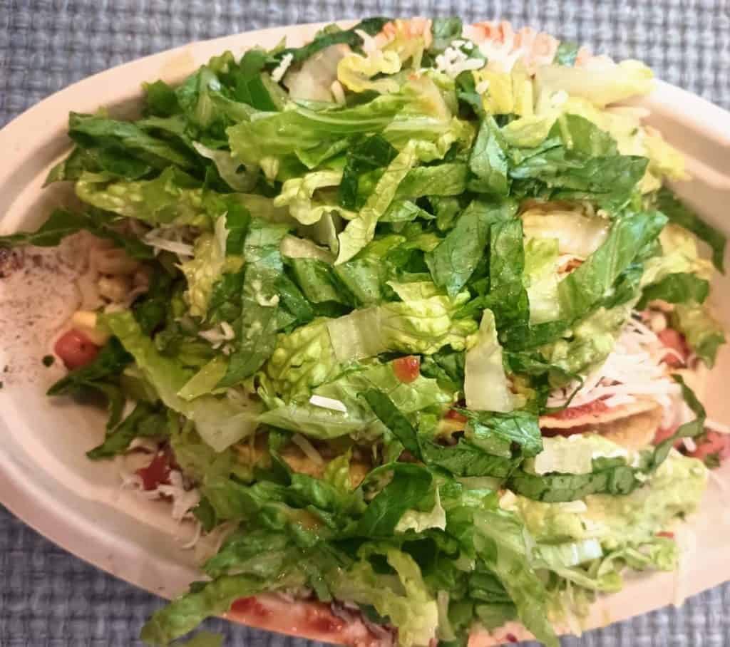 3 tacos topped with lettuce.
